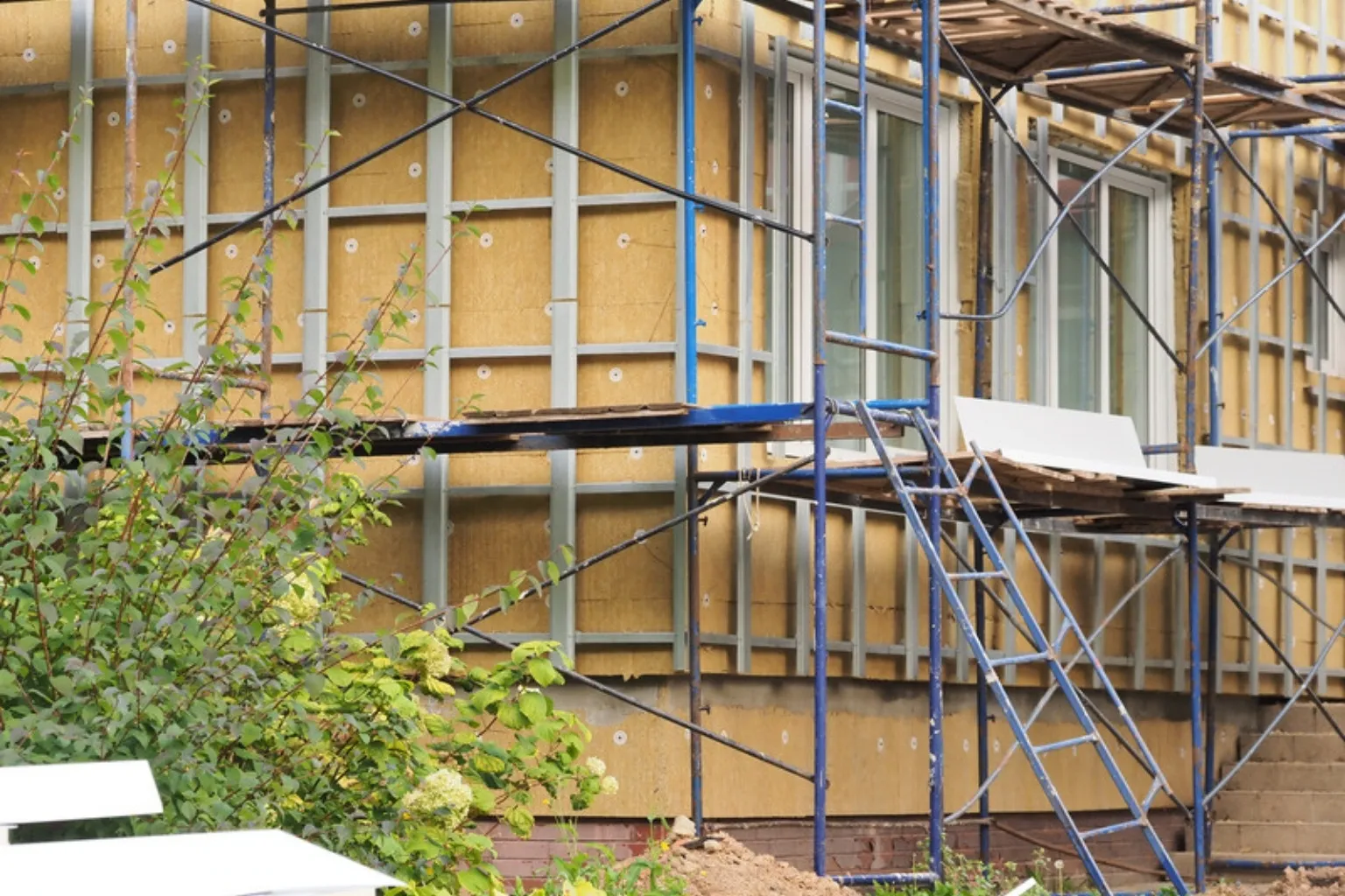 Husfacade med stillads under udvendig efterisolering